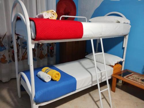 a bunk bed with a red and white blanket at PignaRossa Appartamenti in Mongiove