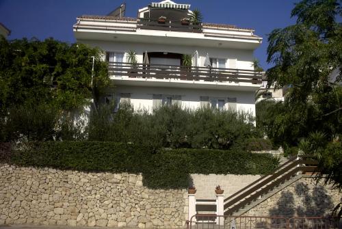 a white building with a balcony on top of a wall at Apartments Antoana in Hvar