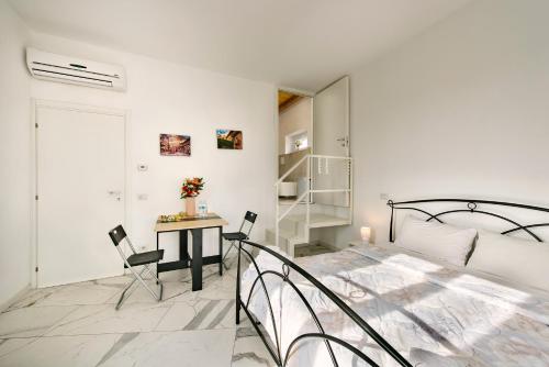 a bedroom with a bed and a table and chairs at Villa Dei Sogni - Camera accesso indipendente Vicino Ospedale Borgo Trento Fiera Arena di Verona in Verona