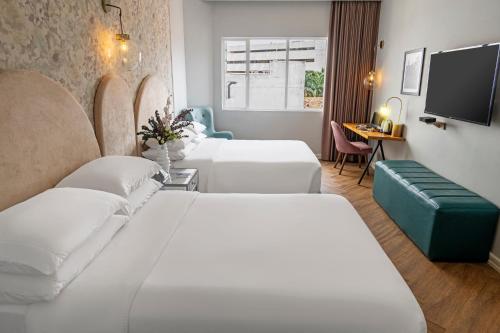 a hotel room with two beds and a tv at Faranda Collection Cali, a member of Radisson Individuals in Cali