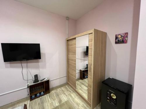 a room with a cabinet with a television on a wall at Seven Stars in Sumy