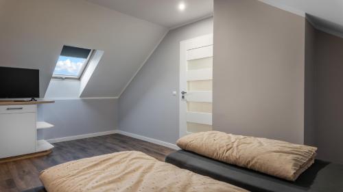 a bedroom with a bed and a tv and a window at Przytulisko Leszczewek in Leszczewek