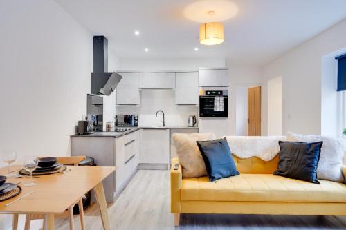 a living room with a yellow couch and a kitchen at No 4 at The Rocketroom Apartments in Berwick-Upon-Tweed