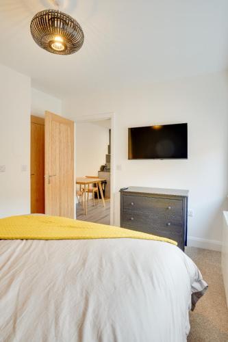a bedroom with a bed with a tv on the wall at No 4 at The Rocketroom Apartments in Berwick-Upon-Tweed