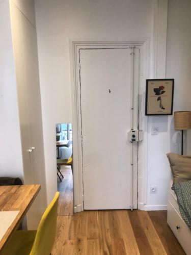 a white door in a room with a table and a desk at Studette au cœur du marais in Paris