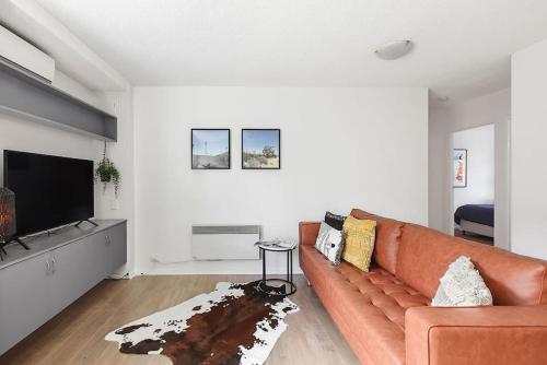 a living room with a couch and a flat screen tv at Bright, Stylist apartment in Richmond Terrace in Melbourne