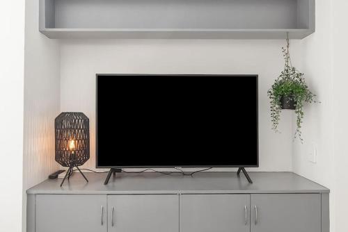a flat screen tv sitting on top of a cabinet at Bright, Stylist apartment in Richmond Terrace in Melbourne