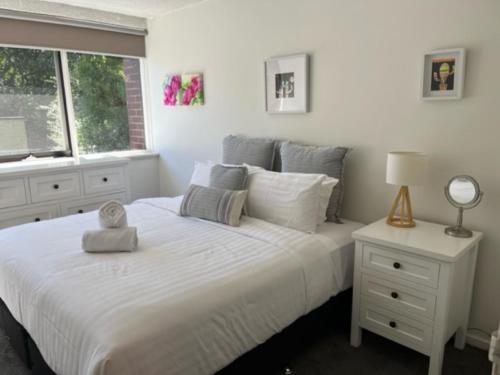 a bedroom with a white bed and a window at Bright, Stylist apartment in Richmond Terrace in Melbourne
