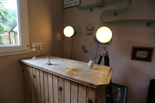 un comptoir en bois dans une pièce avec deux lumières allumées dans l'établissement Jolie maison sauna piscine, à Brest