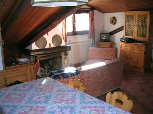 a room with a table and chairs and a fireplace at Mansarda Jouvenceaux in Sauze dʼOulx