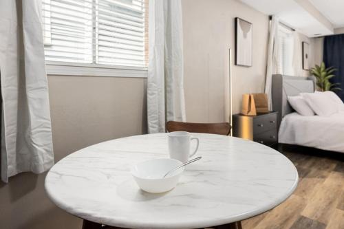 a white table with a bowl on it in a living room at Stylish Studio Apartment with Modern Touches in Peoria