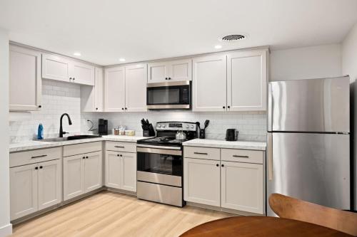 a kitchen with white cabinets and a stainless steel refrigerator at The Silo 6 - 1BD Modern Abode in Morton