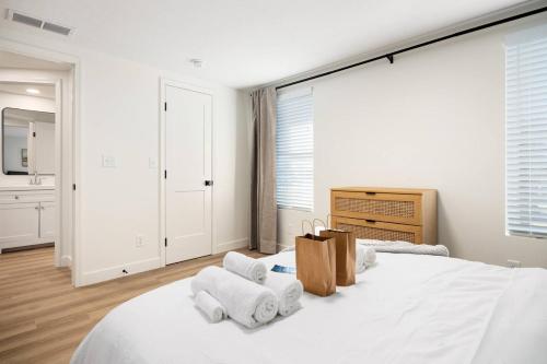 a white bedroom with a large bed with towels on it at The Silo 6 - 1BD Modern Abode in Morton