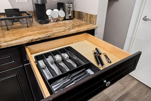 a kitchen counter with a drawer filled with utensils at Stylish Studio Apartment with Modern Touches in Peoria