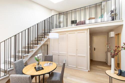 a living room with a staircase and a table and chairs at Hotel Porta San Mamolo in Bologna