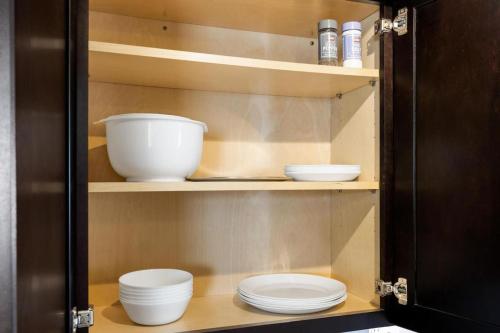 a cupboard with plates and bowls in it at the susan - a cozy, comfy 1bd suite in Peoria
