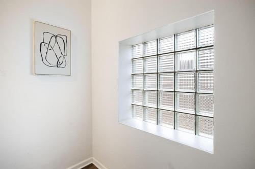 a white room with a window and a picture at the susan - a cozy, comfy 1bd suite in Peoria