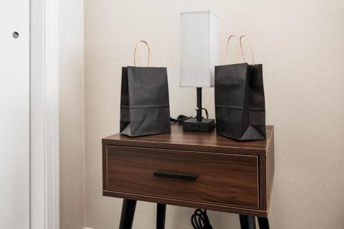 two bags on top of a dresser with a lamp at Chic and Comfortable 1BR Apartment near Bradley U in Peoria