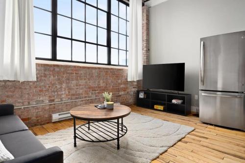 a living room with a table and a refrigerator at Chic Loft in Peoria Warehouse District in Peoria