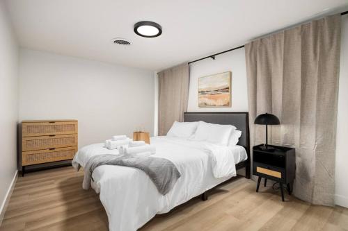 a white bedroom with a large bed and a dresser at The Silo 5- 1 BD Urban Haven in Morton