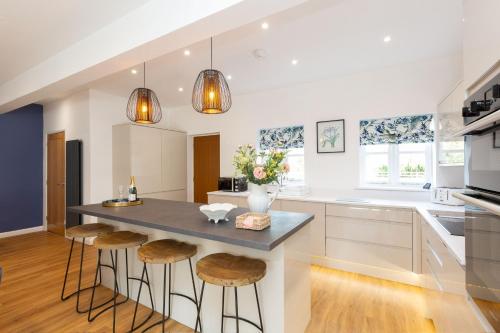 a kitchen with a large island with stools at The Caradoc in Shrewsbury