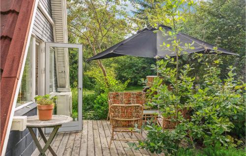 a patio with an umbrella and a table and chairs at 3 Bedroom Stunning Home In Ebeltoft in Ebeltoft