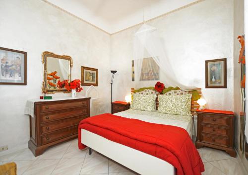 una camera da letto con un letto con una coperta rossa e uno specchio di Oasi di pace a Firenze