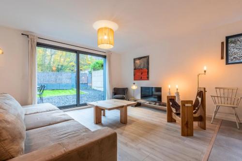 a living room with a couch and a table at Maison 3 chambres avec jardin & parking, prox tram in Wasquehal
