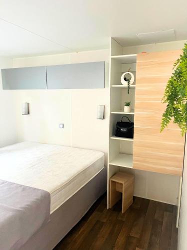 une chambre avec un lit et une plante en pot dans l'établissement Village de chalets et camping La Pierre de l'Aigle, à La Bréole