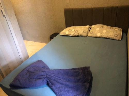 a bed with a purple bow on top of it at Peró Beach Hospedaria in Cabo Frio