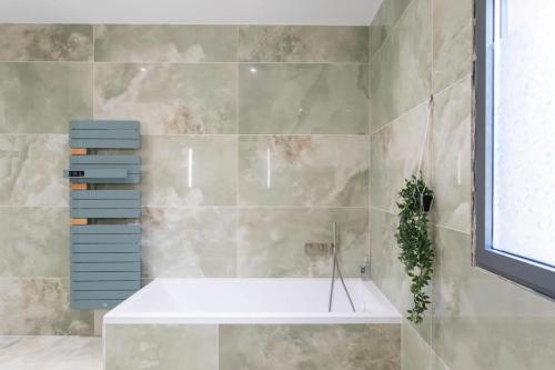 La salle de bains est pourvue d'une baignoire et d'un mur en carrelage. dans l'établissement #53 St Paul Villa Swimpool AC Carpark BBQ for 8 Guest, à Saint-Paul-de-Vence