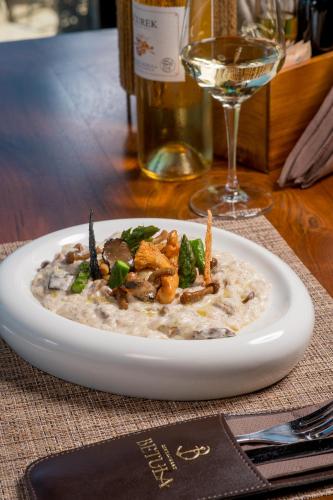 a plate of food on a table with a glass of wine at Luxury Sea Residence by Kristina in Tivat