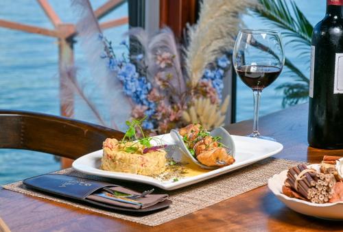 a table with a plate of food and a glass of wine at Luxury Sea Residence by Kristina in Tivat