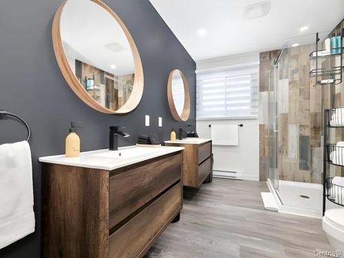 a bathroom with two sinks and a mirror at Twin Lake Retreat - Hot Tub & Private Beach in L'Ange-Gardien