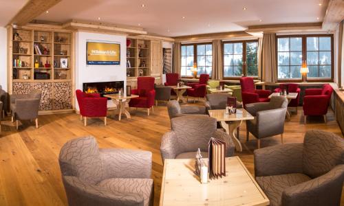 a restaurant with tables and chairs and a fireplace at Hotel Karl Schranz in Sankt Anton am Arlberg