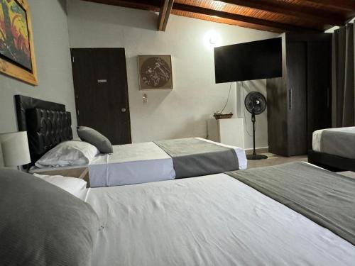 a hotel room with two beds and a flat screen tv at Gemas San Joaquin 1 in Medellín