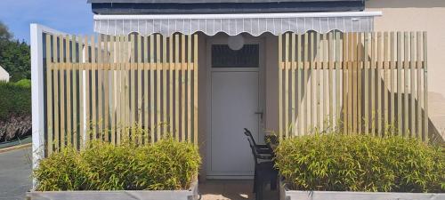 a house with a gate and a white door at Location, 10 mn des plages. in Saint-Coulomb