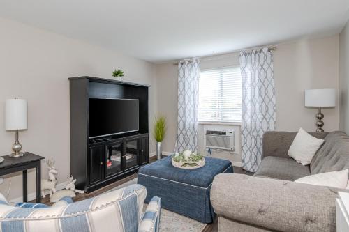 a living room with a couch and a tv at Stylish Retreat W Modern Comforts! Prime Location in Kettering