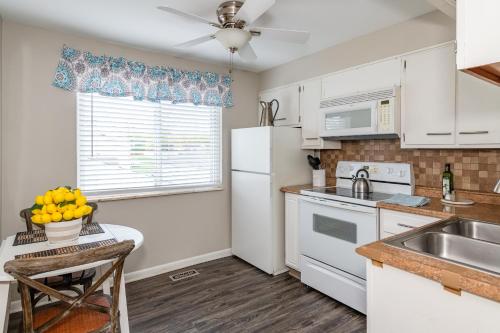 a kitchen with a white refrigerator and a sink at Stylish Retreat W Modern Comforts! Prime Location in Kettering