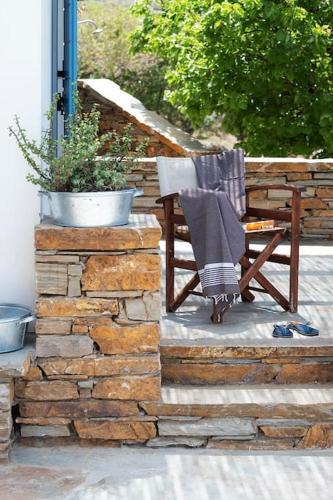 a wooden chair with a blanket sitting on a patio at Luxury Cycladic Villa-Enjoy Infinity Pool Sunsets in Koundouros