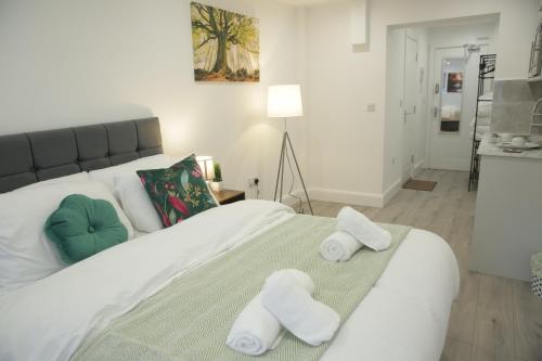 a bedroom with a large white bed with towels on it at Luton Nook and Kitchen 4 mins to Luton AirPort in Luton