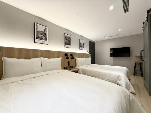 a hotel room with two beds and a flat screen tv at N2 Hotel in Taichung
