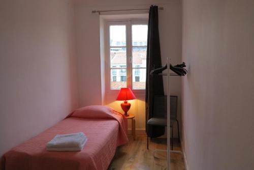 um pequeno quarto com uma cama e uma janela em Viva Riviera - 10 Rue Commandant André em Cannes
