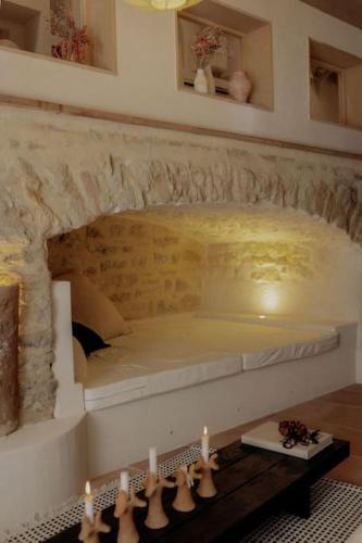 une chambre avec un lit dans un mur de pierre dans l'établissement Pausette, à Fanjeaux