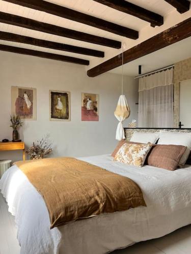 une chambre avec un grand lit dans une pièce avec des plafonds en bois dans l'établissement Pausette, à Fanjeaux