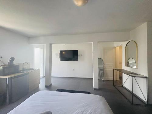 une chambre blanche avec un lit, un lavabo et une salle de bain dans l'établissement Charmant Studio 3 avec Jacuzzi à Quéven, à Quéven