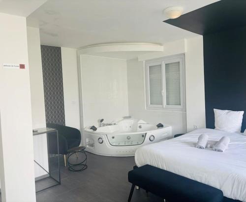 une chambre avec un lit et une baignoire dans l'établissement Charmant Studio 3 avec Jacuzzi à Quéven, à Quéven