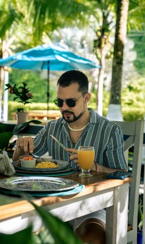 a man sitting at a table with a plate of food at Hotel Villas Gaia Ecolodge in Uvita