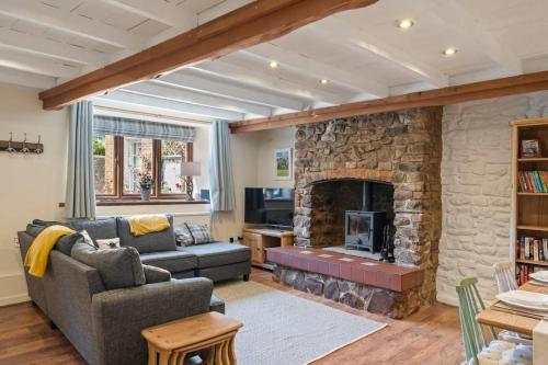 a living room with a large stone fireplace at Beautiful Cottage Parking Central Dunster in Minehead
