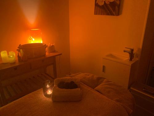 a bathroom with a bed with a candle and a sink at Le Clos de la tour in La Tour-du-Pin
